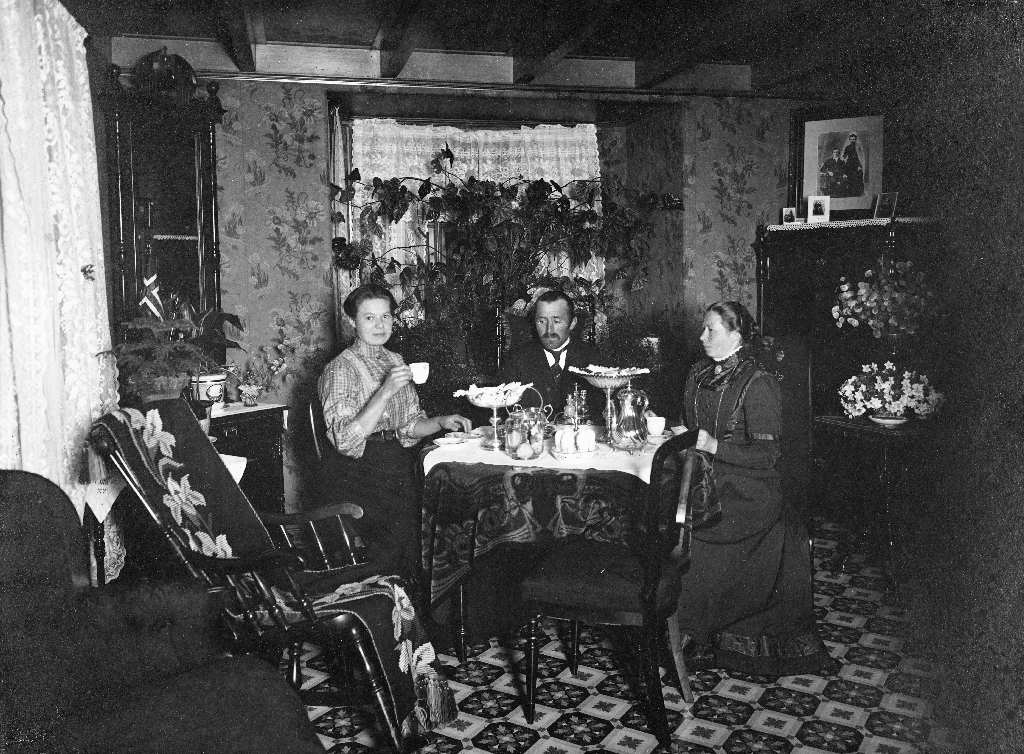 Interiør frå stova til Lisa og Torger Fotland på Bryne ca 1915. F. v. : Anne Margrethe Vestly (1890 - ), Torger Fotland (1870 - 1944), Lisa Fotland (1873 - ).
Anne Margrethe og Lisa Fotland er søsken og født på Serigstad.
