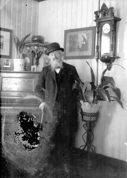 Portrett. Eldre mann med skjegg, dress, hatt. Stueinteriør. - Maihaugen ...