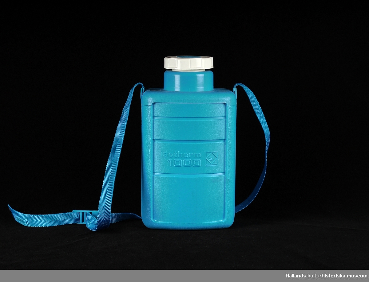 Blå termosflaska i plast med vit skruvlock innehåller en liter. På flasken sitter ett blå band för att bära. Den är av märket: Camping gaz international, model: Lsotherm 1000