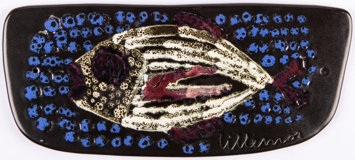 Väggplatta, flintgods, dekor av fisk. Glasyr Mangania med blått, vitt och rött mönster. Formgiven av Lillemor Mannerheim.