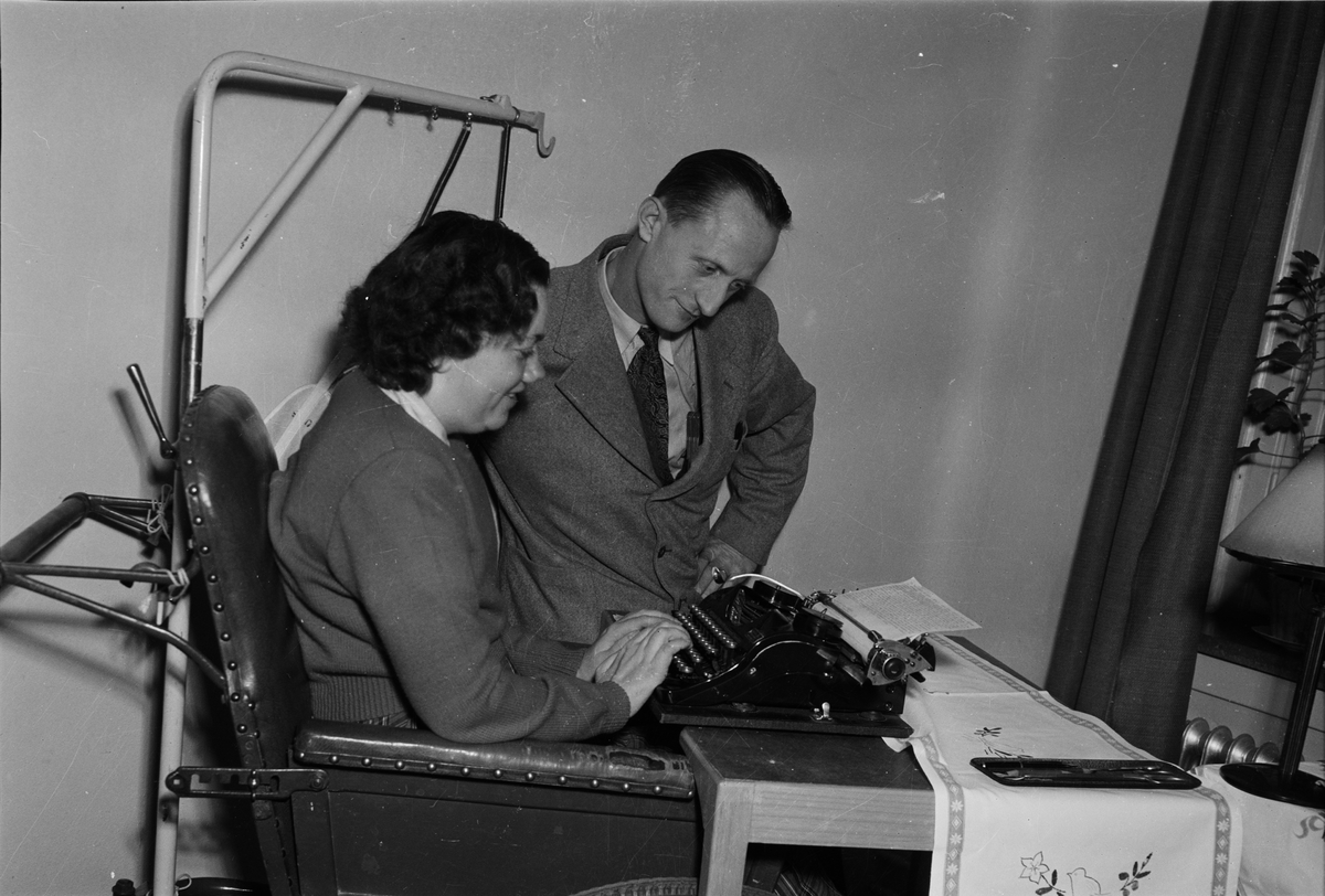 En kvinna vid skrivmaskin och en man står bredvid, Uppsala 1953