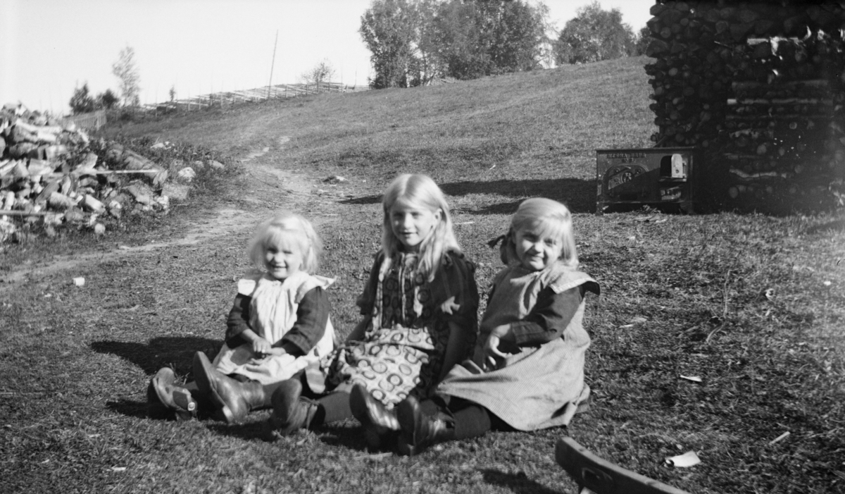 Tre barn i det grønne - ovn fra Mesna Bruk i bakgrunnen, antakelig på Linjordet i Østre Gausdal
