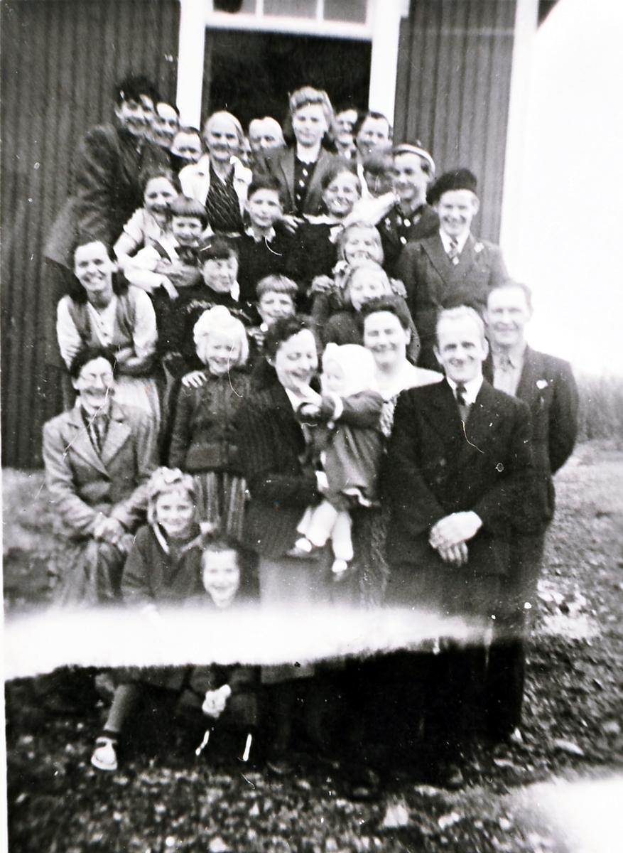 Familie utenfor røstet av Borterstua i Hofsøya.