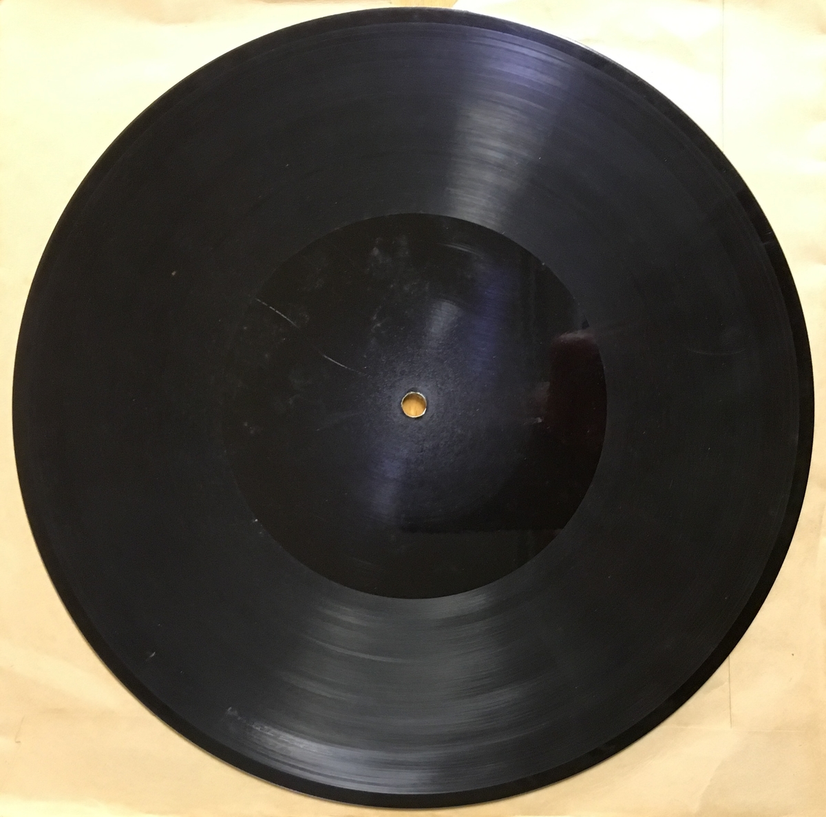 Grammofonplate i svart skjellakk og plateomslag i papir.