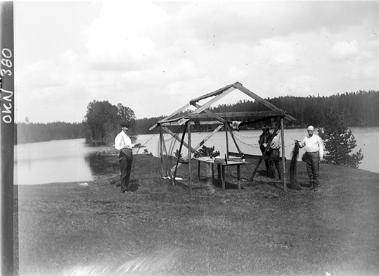 Fyra män vid fiskenät till torkning, Riddarhyttan.
