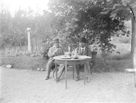 Två män vid trädgårdsbord, Riddarhyttan.