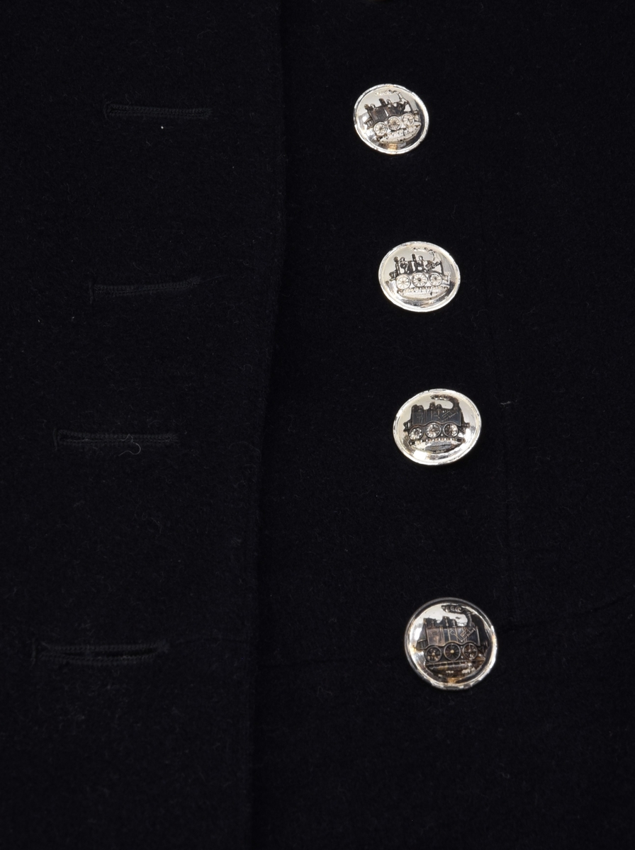 Syrtut av svart kläde med vita passpoaler. Syrtuten har två knapprader med knappar av försilvrad metall med ett präglat lok som motiv. Baksidan av syrtuten har ett sprund som omges av tre präglade knappar på vardera sidan. Till syrtuten hör ett par byxor, Jvm 08861-2.

En tillhörande väst, märkt "Jensén" har funnits tidigare.