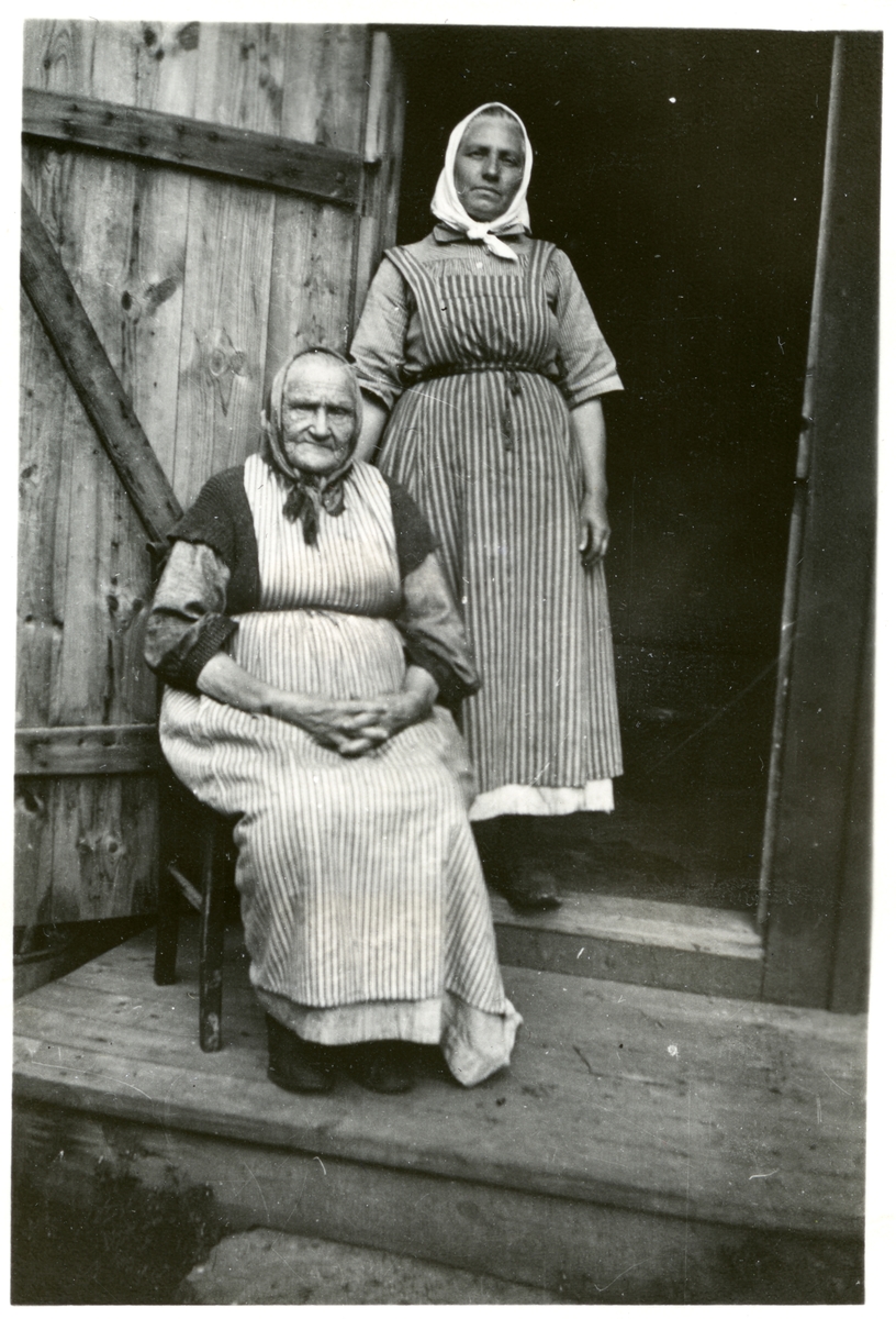 Dingtuna sn, Västerås.
Stockkumla gård. Två kvinnor med randiga förkläden och "hucklen". 
1898-1910.