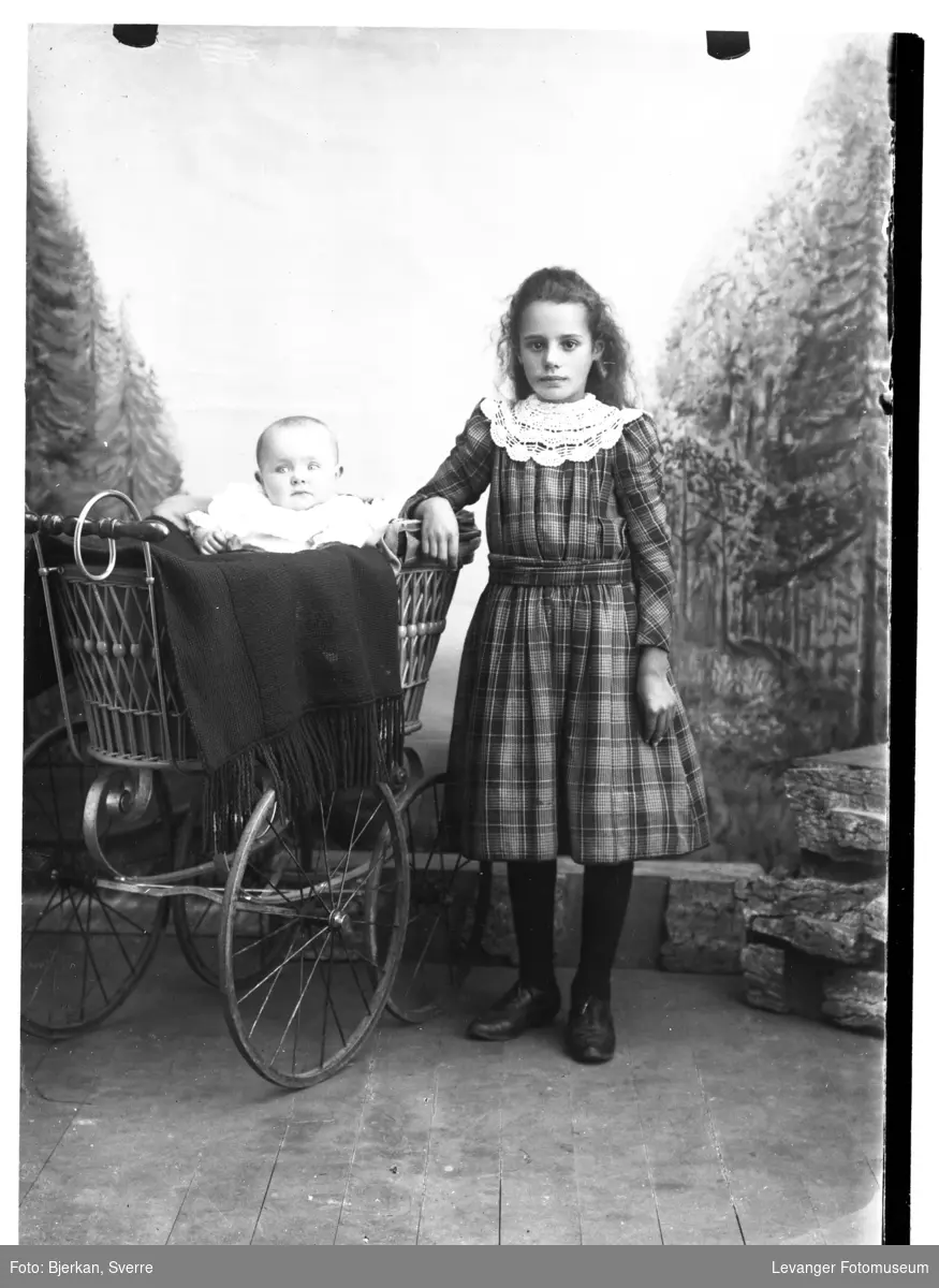 Portrett av Margot Dillan  med et spebarn, trolig søsken.