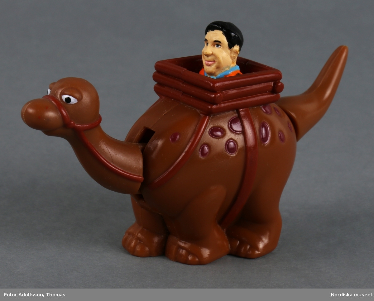 Mekanisk leksak i form av en brun dinosaurie med ryttare som föreställer seriefiguren Fred Flinta. Dinosauriens namn är Dino. Huvudet och svansen är rörliga och om man drar i svansen hoppar gubben upp och ned.