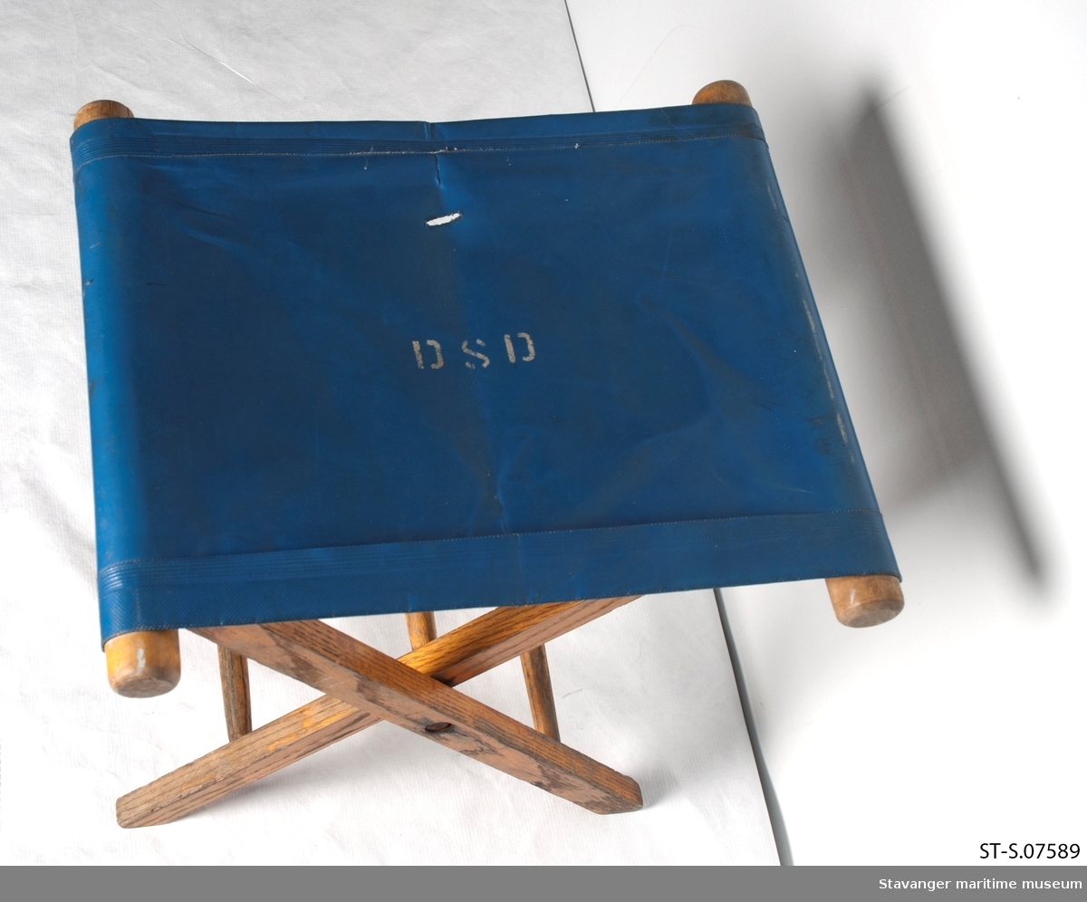Klappstol i tre med blått plast sete, har også DSD logo på setet.