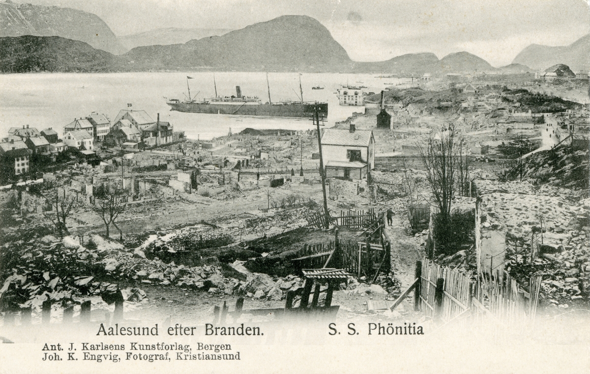 Oversiktsbilde over Ålesund sett mot sør- vest. Byen står fortsatt i ruiner etter bybrannen. Dampskipet S. S. Phönitia ligger ankret ved byen.