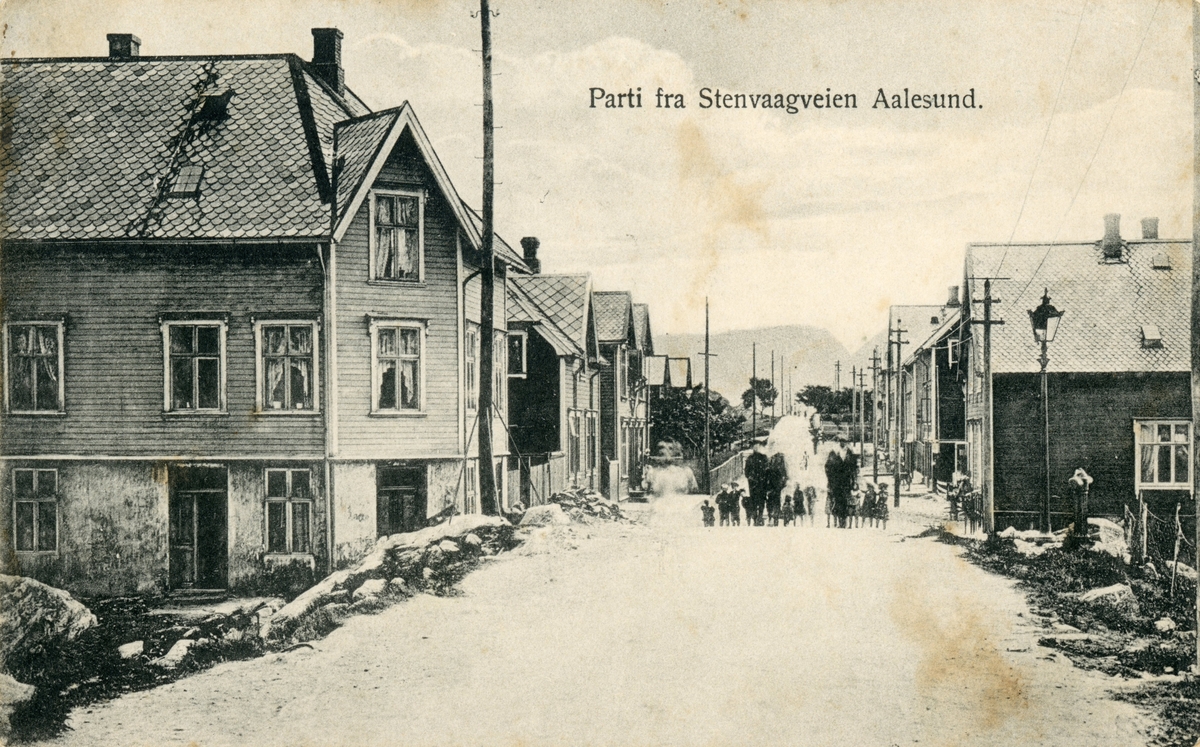 Motiv av gatemiljøet i Steinvågveien, Ålesund. En familie står oppstilt midt i gata.