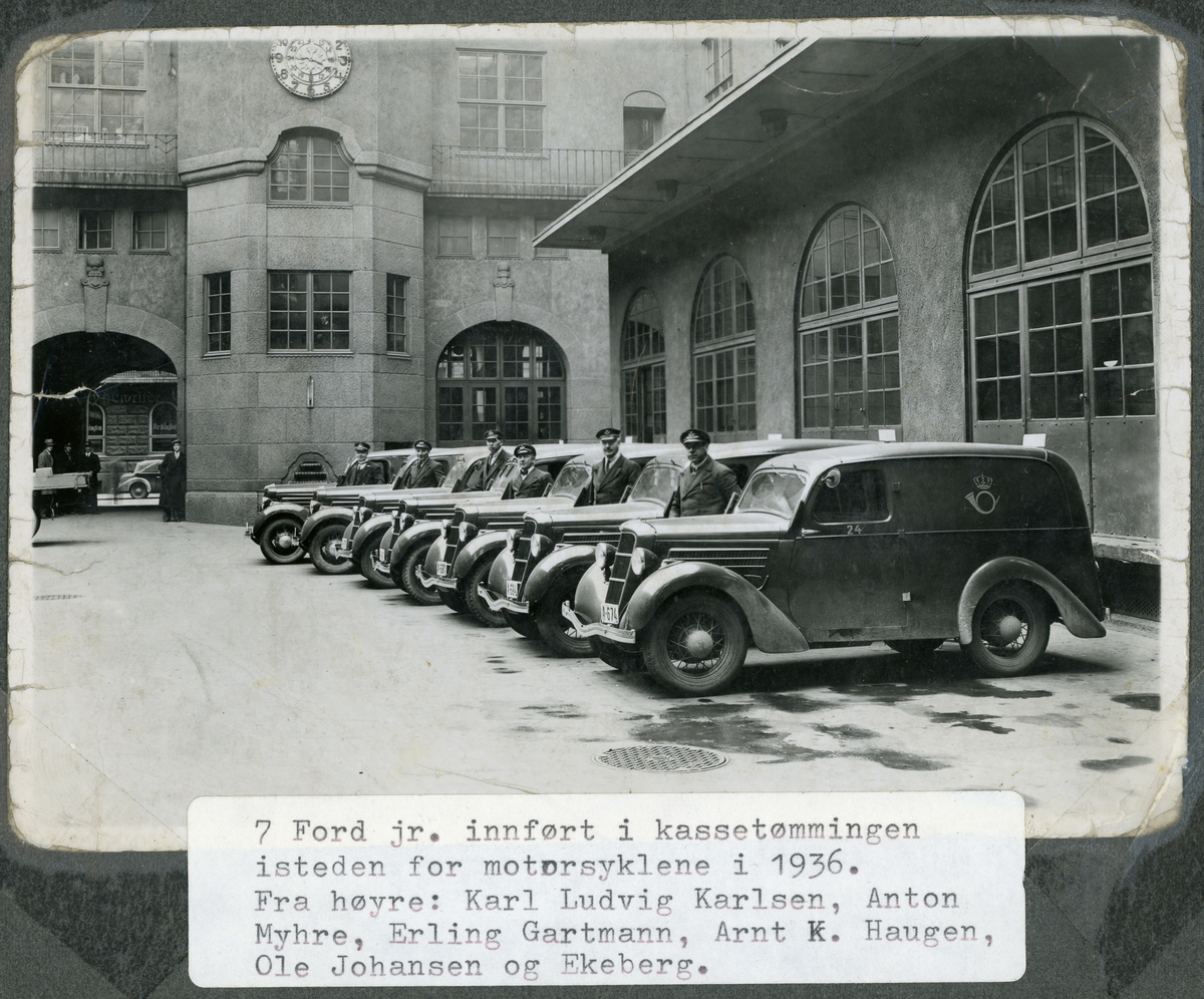 transport, bil, Oslo postgård, 7 postbiler parkert på gårdplassen inne i gården, menn, 6 postsjåfører i postuniform ved bilene, postlogo, bilskilt med reg.nr A-674, A-684, A-681. Ford Junior de luxe varebiler, årsmodeller 1936.