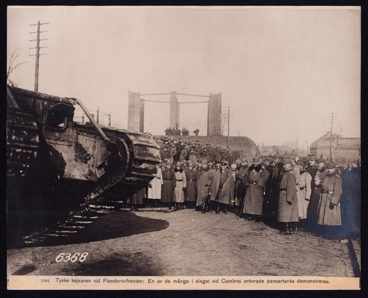 Bilden visar den tyske kejsaren Vilhelm II på en trupbesök i Frankrike. Han beskådar en engels stridsvagn omringad av en stor åskådarmassa.
