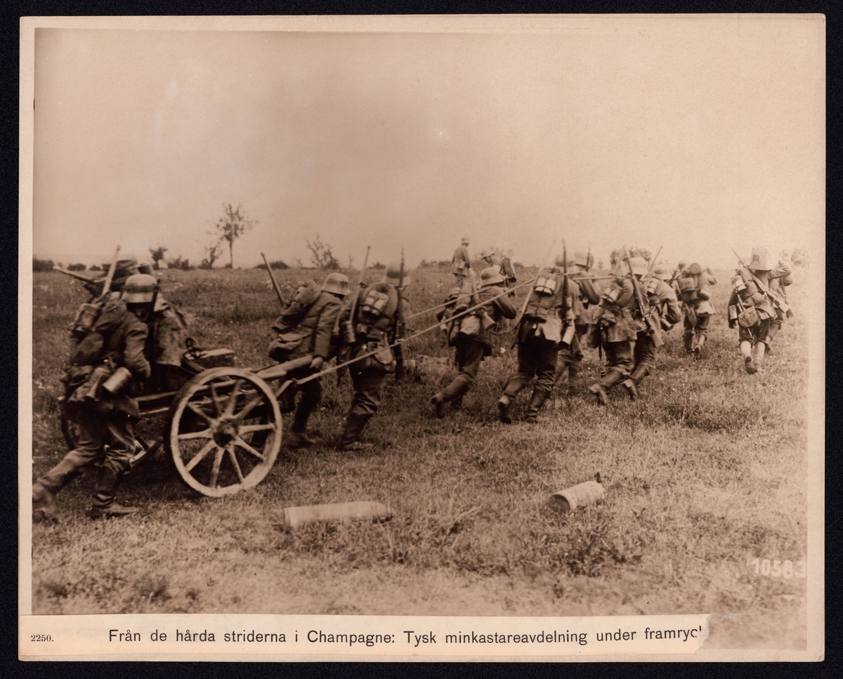 På bilden syns en kolonn soldater som måste dra sin artilleripjäs själv under förflyttningen. Bredvid de ser man två projektiler liggande i gräset.