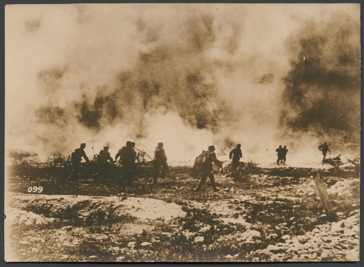 Bilden visar infanterisoldater som springer över slagfältet under ett pågående strid. I bakgrunden täcker stora rökmoln från artillerield och explosioner sceneriet.