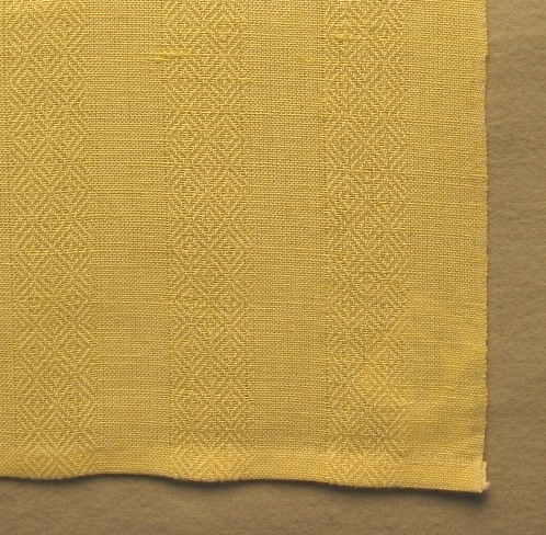Handduk vävd med tuskaft och gåsögon i ränder i varpriktningen samt halvblekta och färgade tvärränder i inslagsriktningen. Ränderna är 25 mm breda. Varpen består av tvåtrådigt blekt bomullsgarn och inslaget av entrådigt halvblekt och färgat lingarn. Handduken med inv.nr.0005:1 har grå rand, 0005.2 har turkos, 0005.3 har gul och 0005:4 är enfärgad gul.

Handduken har en pappersetikett fastknuten med texten:"Gås" tuskaft gåsögon, material bomg 16/2 ling 16/1, form/ursprung Ann-Mari Nilsson, pris ej till salu". På andra sidan är det en tryckt spånfågel med texten "Länshemslöjden SKARABORG SKÖVDE". Handduken har en tråcklad smal fåll i vardera kortsidan. Mitt på ena kortidan är ett smalt vitt band fastsytt som hank.

Handduken med modellnamnet Gås är formgiven av Ann-Mari Nilsson och tillverkad av Länshemslöjden Skaraborg. Den finns med  på sidan 16 -17 i vävboken Inredningsvävar av Ann-Mari Nilsson i samarbete med Länshemslöjden Skaraborg från 1987, ICA Bokförlag. Se även inv.nr. 1-4,6-40.