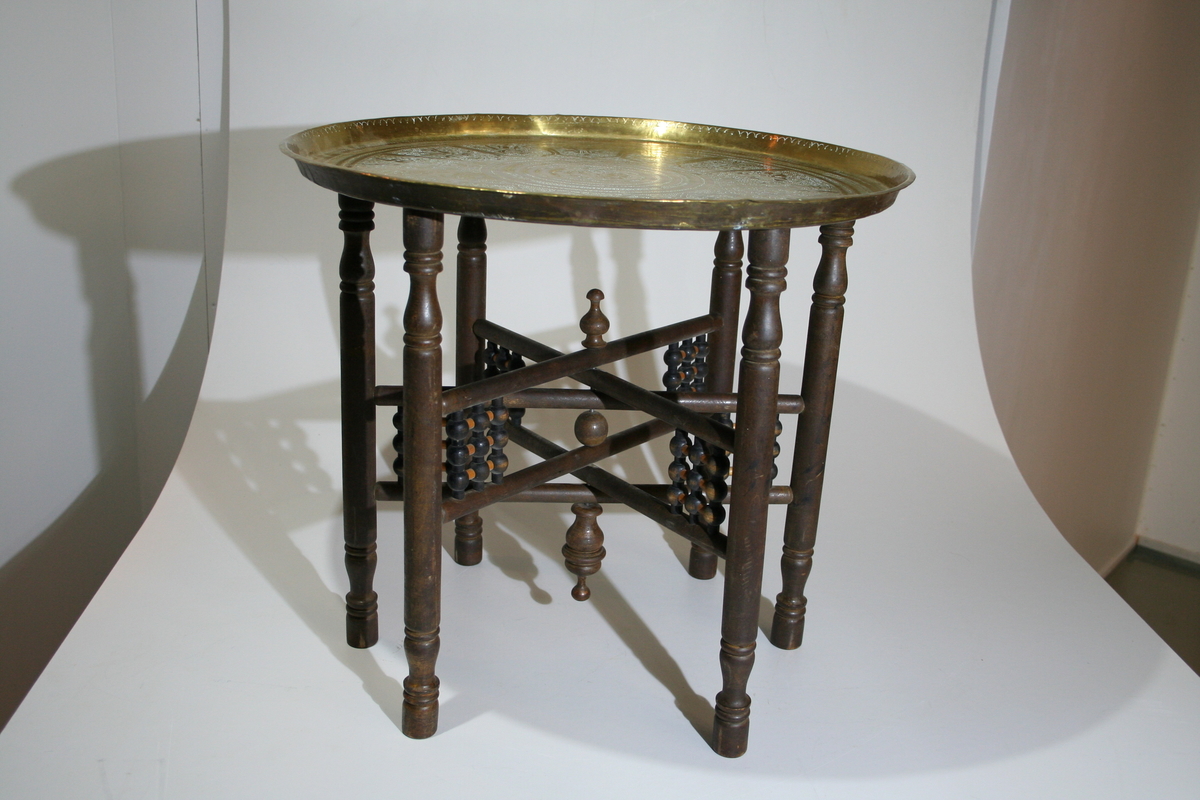Bordet består av et brunt, sammenleggbart understell med dreide kuler, messingbrett med gravert dekor. Brettet ligger løst oppe på understellet. Røkebodet er i orientalsk stil.