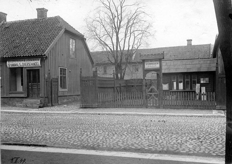 J. E. Nelssons stenhuggeri har en filial på Kyrkogatan 8 i Jönköping. I huset intill finns "Magnusson & Johanson Spannmåls & Diversehandel".