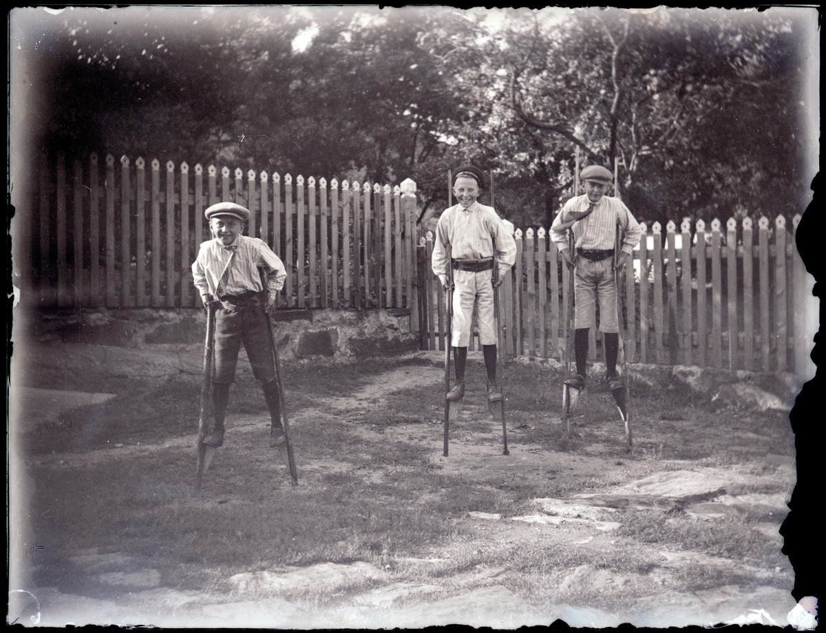 Barn på styltor i engelska trädgården på Härön. Till höger Torsten Lachonius född 1903 och till vänster Erik Lachonius född 1908. Pojken i mitten okänd.