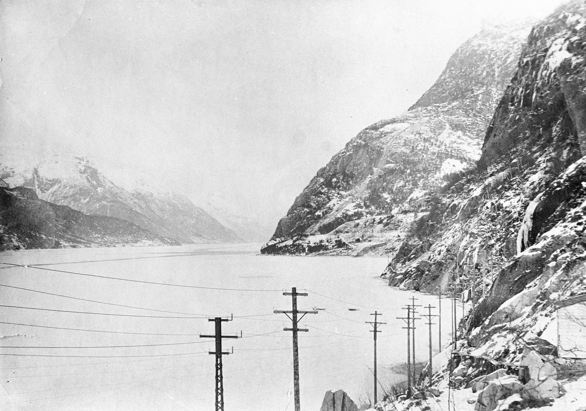 Kraftlinjer og islagt Sørfjord med Tyssedal i bakgrunn