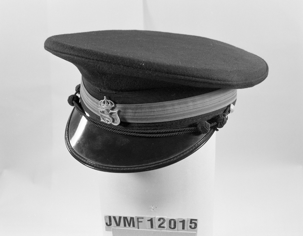 Skärmmössa av mörkblått kläde med 20 mm högrött resårband (tågklarerartecken) ovanpå ett svart mössband.
Mössmärke: krönt SJ

Själva mössmodellen är av 1940-talstyp.