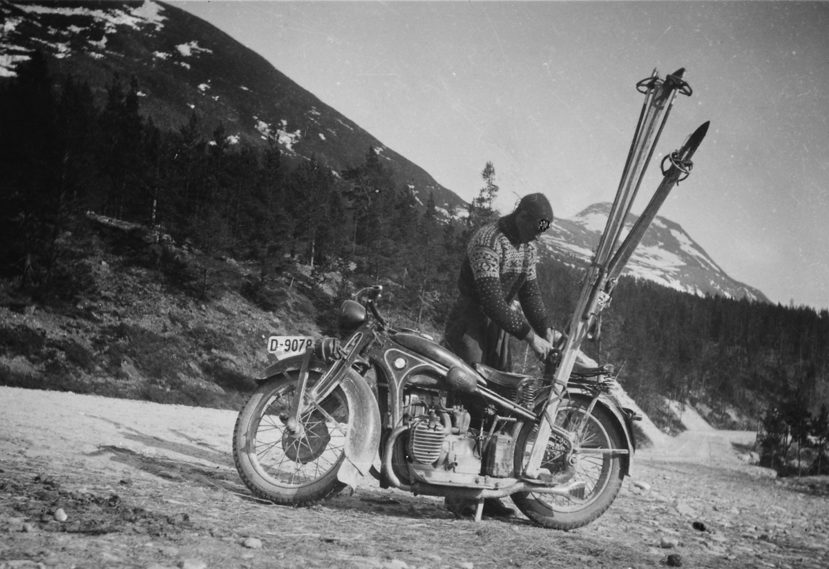 Mann med motorsykkel og ski på bagasjebrettet