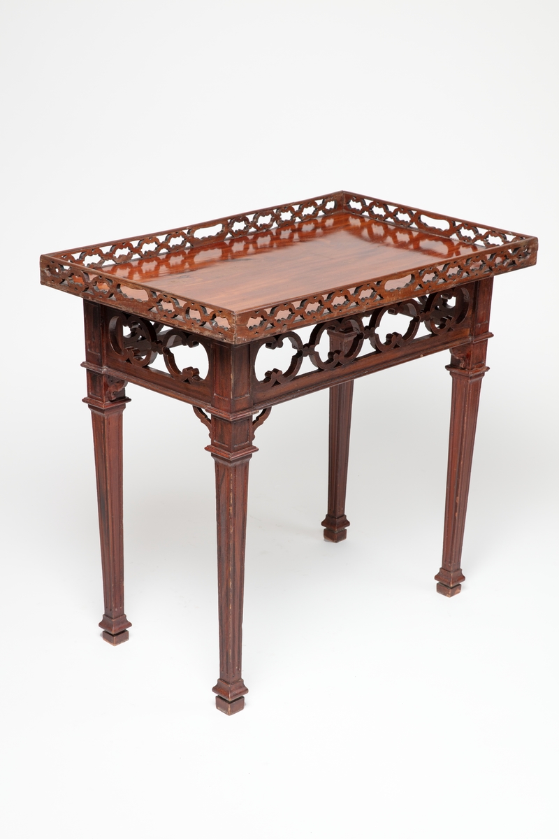 Rektangulært bord med bordplate og galleri i mahogni. Sarg og bein er ådret. Galleri og sarg med dekor av gjennombrutte utskjæringer.