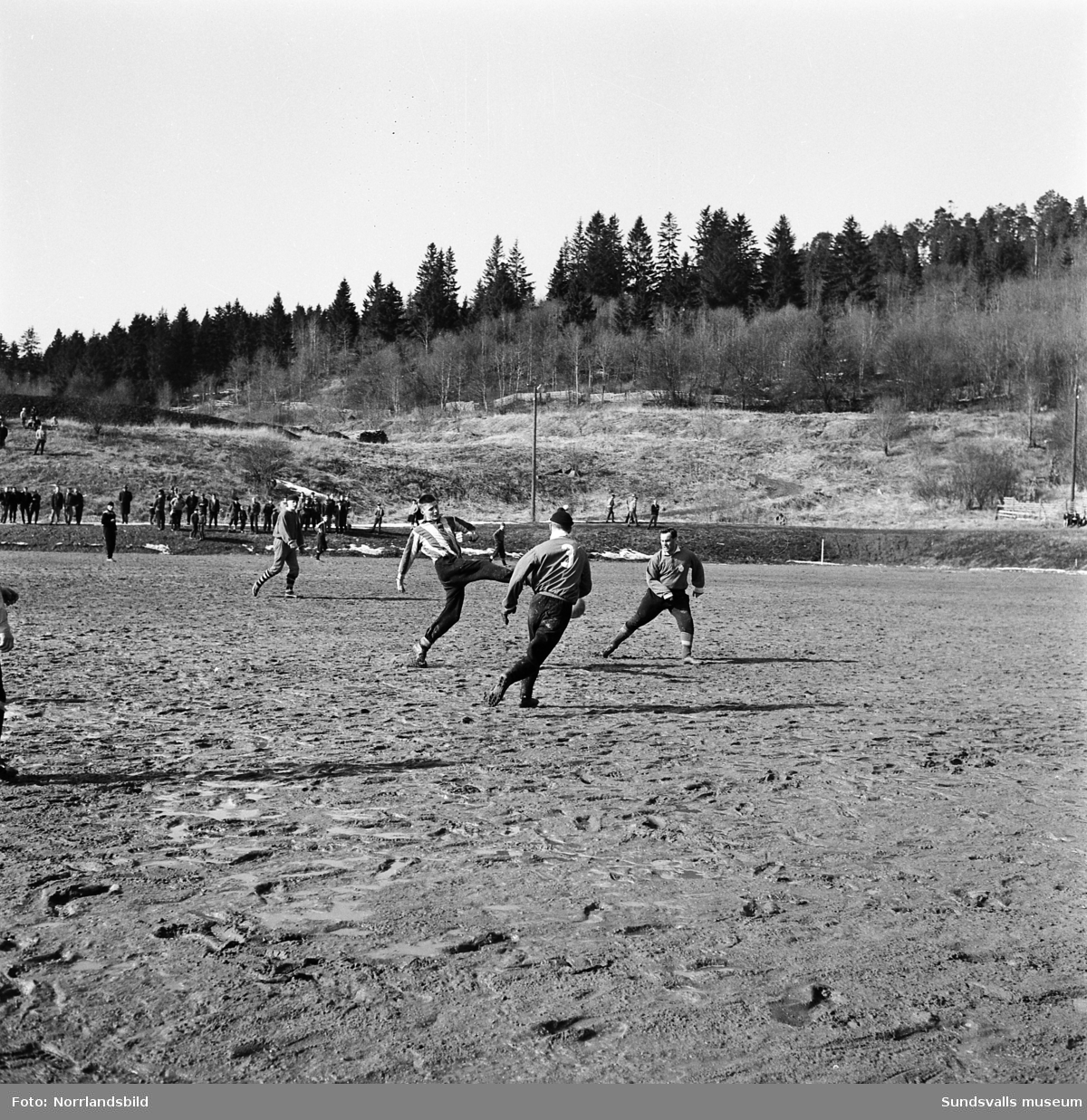 Fotbollsmatch på en lerig Västhagenplan i början av april 1960. GIF Sundsvall vann med 4-1 över Kubikenborg.