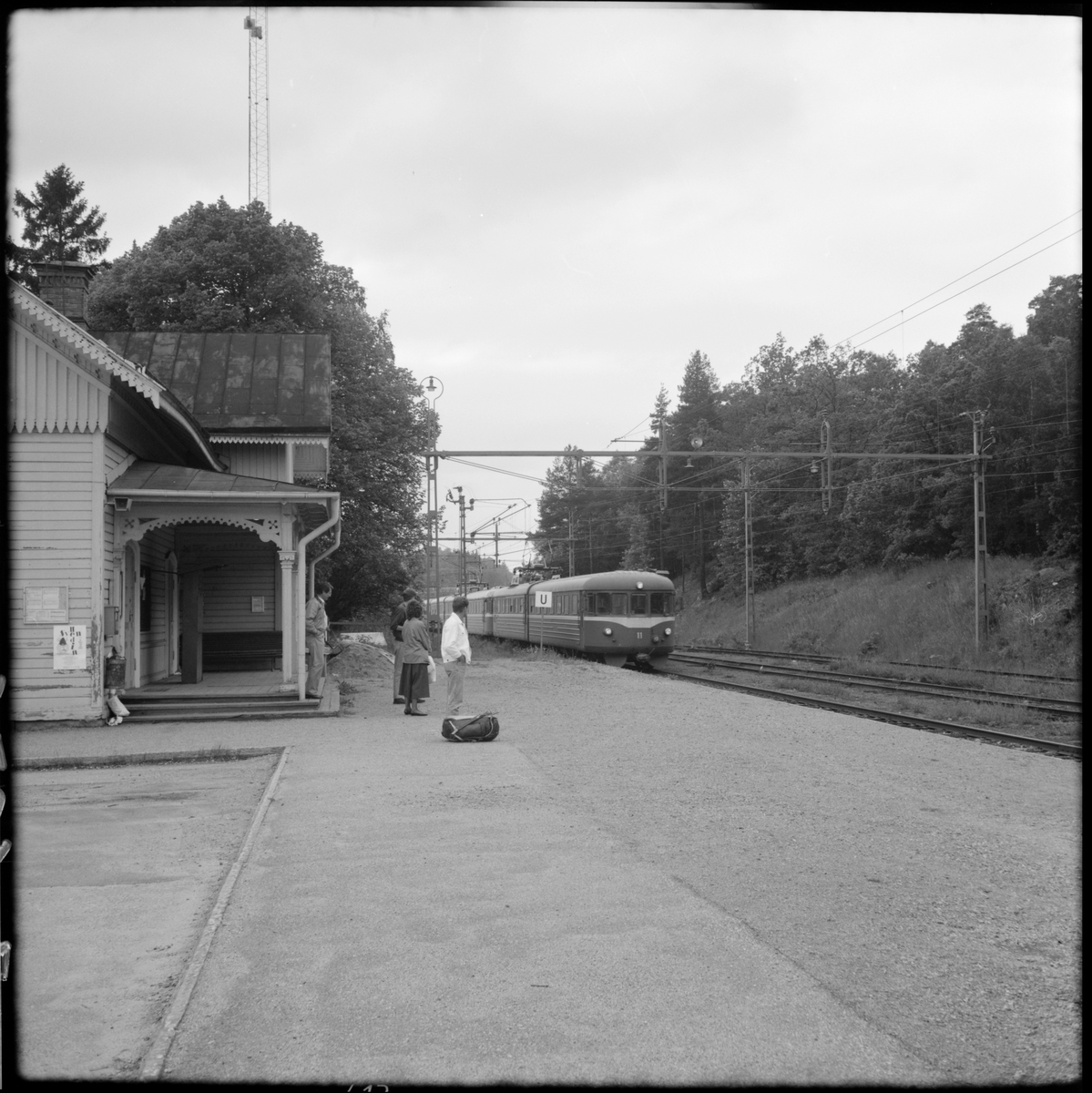 Resande vid Läggesta station där Trafikaktiebolaget Grängesberg – Oxelösunds Järnvägar, TGOJ XX22-11 (225+226) är på ingående.