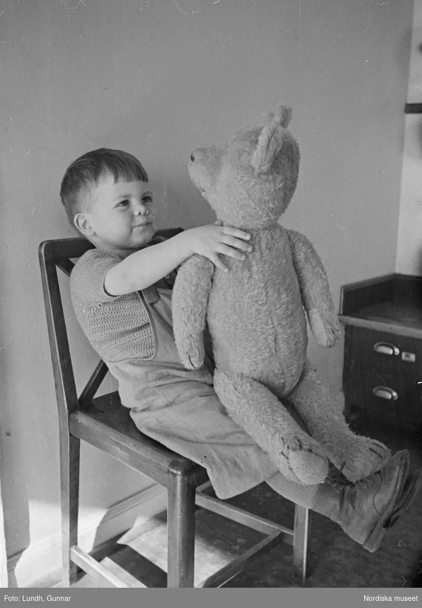 Barn. En pojke håller i en stor nallebjörn. Lekstugan i HSB:s hus i Kvarteret Marmorn på Lundagatan, Södermalm, Stockholm.