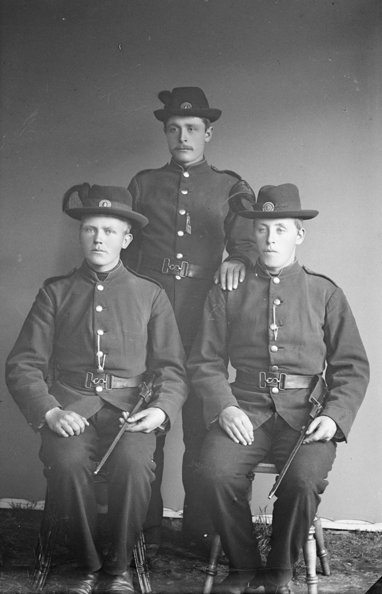 Tre soldater i uniform med hatter. Etter MPLs regnskapsbok er den ene Sigurd Skurdahl.
