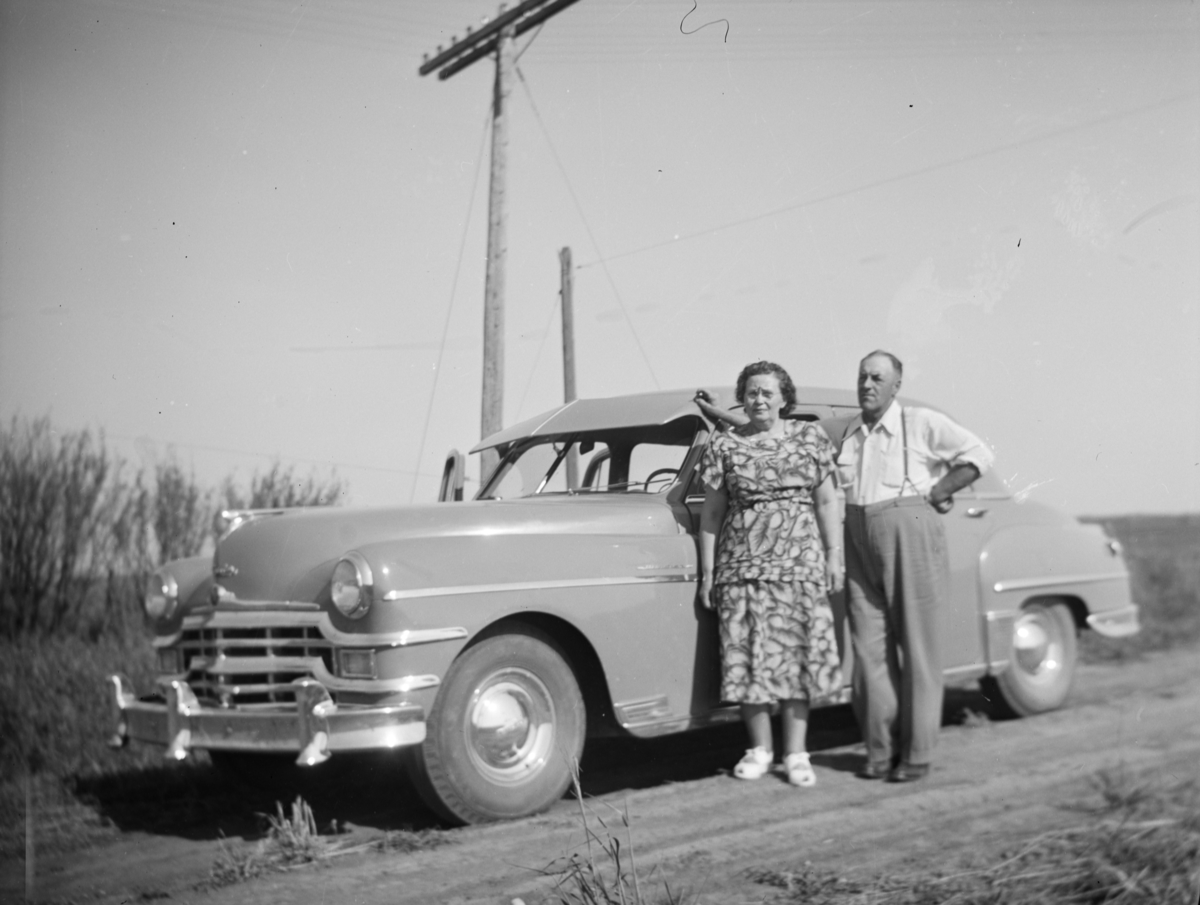 Et eldre par står ved bil. Mulig i Saskatchewan, Canada