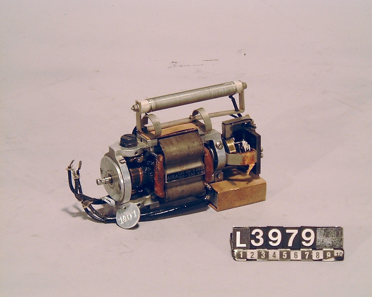 Elektrisk motor till räknemaskin. På apparaten finns även en metallbricka fäst med inv.nr. 1401.