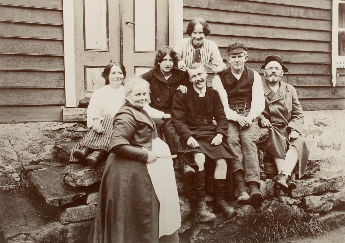 Gruppeportrett av fire kvinner og tre menn på trappa utenfor et hus. Noen identifisert som familien Eng.