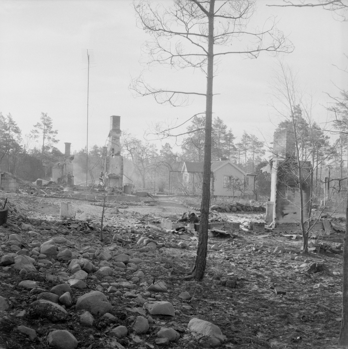 Dagen efter den stora branden i Västervik 1959. Det var vid 14-tiden den 27 augusti som branden startat vid en soptipp väster om Västervik. Inom kort gick branden på en halv mils bredd i frånlandsvind och en katastrof hotade kuststaden med havet som spärr i öster. Förutom Västerviks yrkesbrandkår, borgarbrandkår och olika industribrandkårer deltog i släckningsarbetet brandavdelningar från Norrköping, Linköping, Överum, Gamleby, Hjorted, Hallingeberg och Gladhammar. Från Linköpingsgarnisonen rekvirerades också militär hjälp med 375 man. Från F3 dirigerades även ett flygplan till Västervik med radiobil för att leda släckningsarbetet. Ett väldigt rökmoln fick solen att lysa mattröd över staden och en spökstämning spreds på gatorna. Man förberedde att flera hundra familjer skulle få lämna sina hem vid den omedelbara eldfronten. Med en heroiskt och samfälld insats hejdades dock eldens framfart efterhand och stadens invånare kunde andas ut.