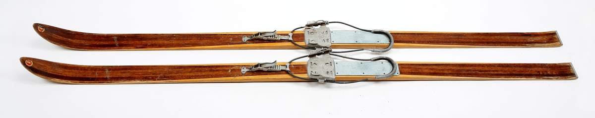 Brune og trehvite treski med kandaharbindinger, av merket Splitkein. Bindinger av typen Gresshoppa.