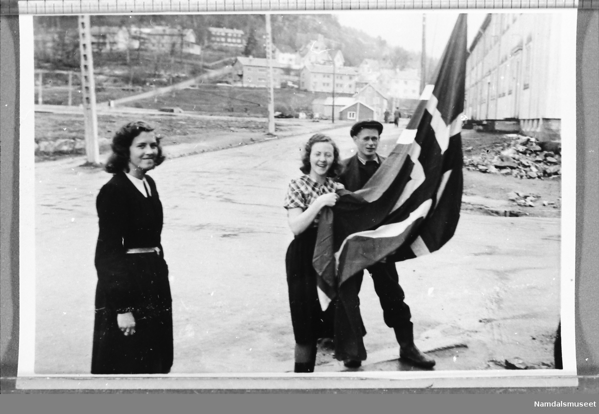 Namsos sentrum, mai 1945. Flagget heises på Namsos E-verks brakke.