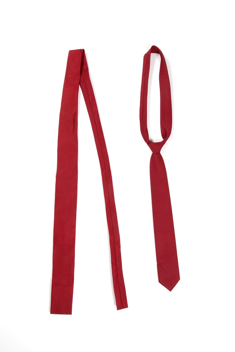 Tilhører en arbeiderkorpsuniform.

To smale slips. Det ene slipset er knyttet og har trolig ikke vært knyttet opp siden det var i bruk.