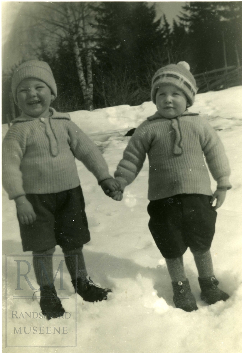Guttene Arve Lynnebakken og Torleif Vekterud hånd i hånd i snøen. 
