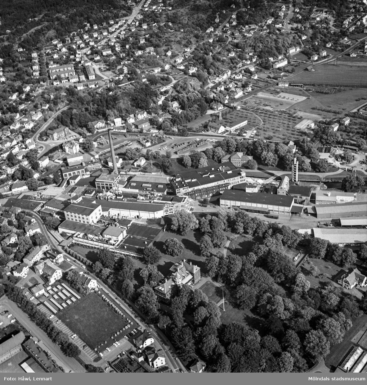 Flygfoto över pappersbruket Papyrus fabriksområde i Mölndal, 9/6 1969. Ovanför fabriksbyggnaderna syns Yngeredsfors fruktodlingar.