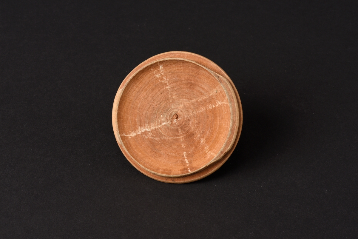 Rund svarvad smörask med lock, tillverkad av trä. Locket har ett runt svarvat knopphandtag. Asken är målad i blågrönt och försett med initaialer, MSD, och årtal, 1804, i rött. På knoppen ett ditmålat kryss och fyra punkter.