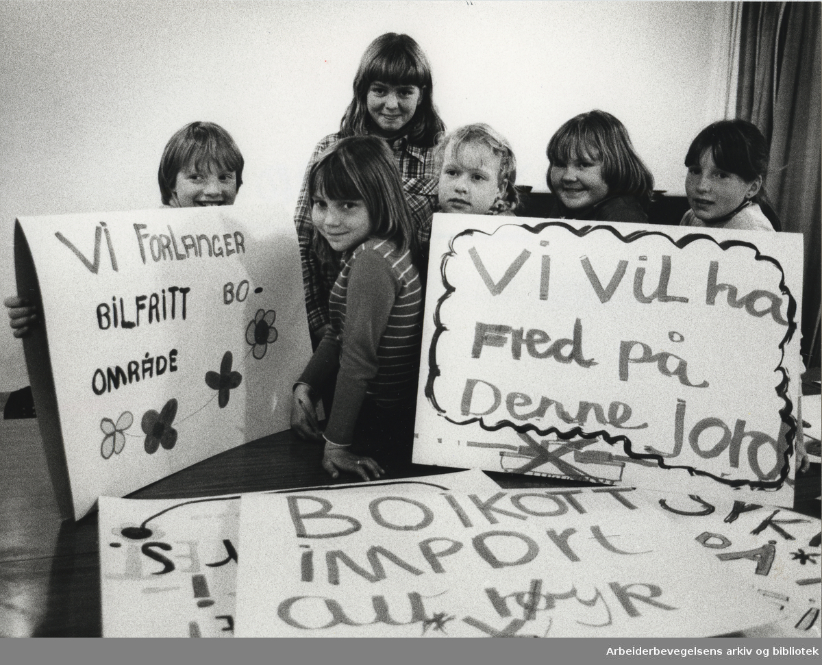 1. mai 1980, Oslo. På plakatene: Vi forlanger bilfritt bo-område. - Vi vil ha fred på denne jord. Tekst fra avisutklipp limt bakpå bildet: Lena, Lise, Stine, Anita, Randi og Nina vet hva de vil demonstrere for på 1. mai.