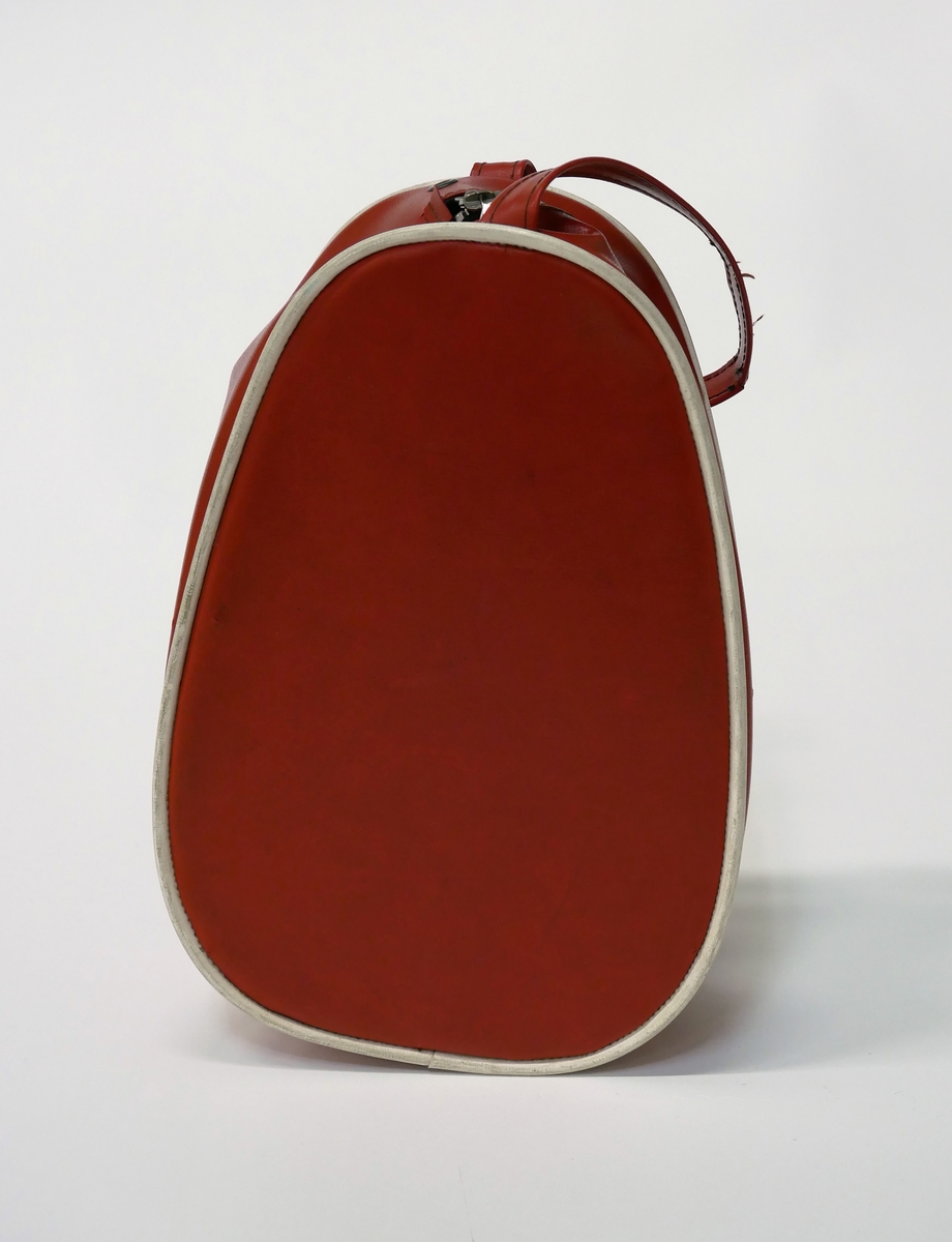 Röd väska av läderimmitation/plast. För att förvara och transportera stickningsarbeten. Väskan har tillhört givaren och kommer från slutet av 1950-talet.