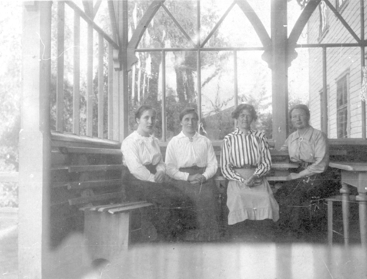 Postkort av fire damer som sit inni ein glassveranda, mest truleg på Fosheim Hotel i Røn.