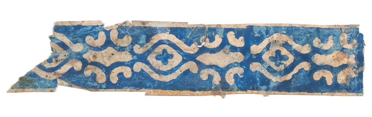 Tapetbård med ornamentalt mönster, tryckt i blått på obestruken botten. En tryckfärg. Ligninfritt papper. Handtryckt. IB