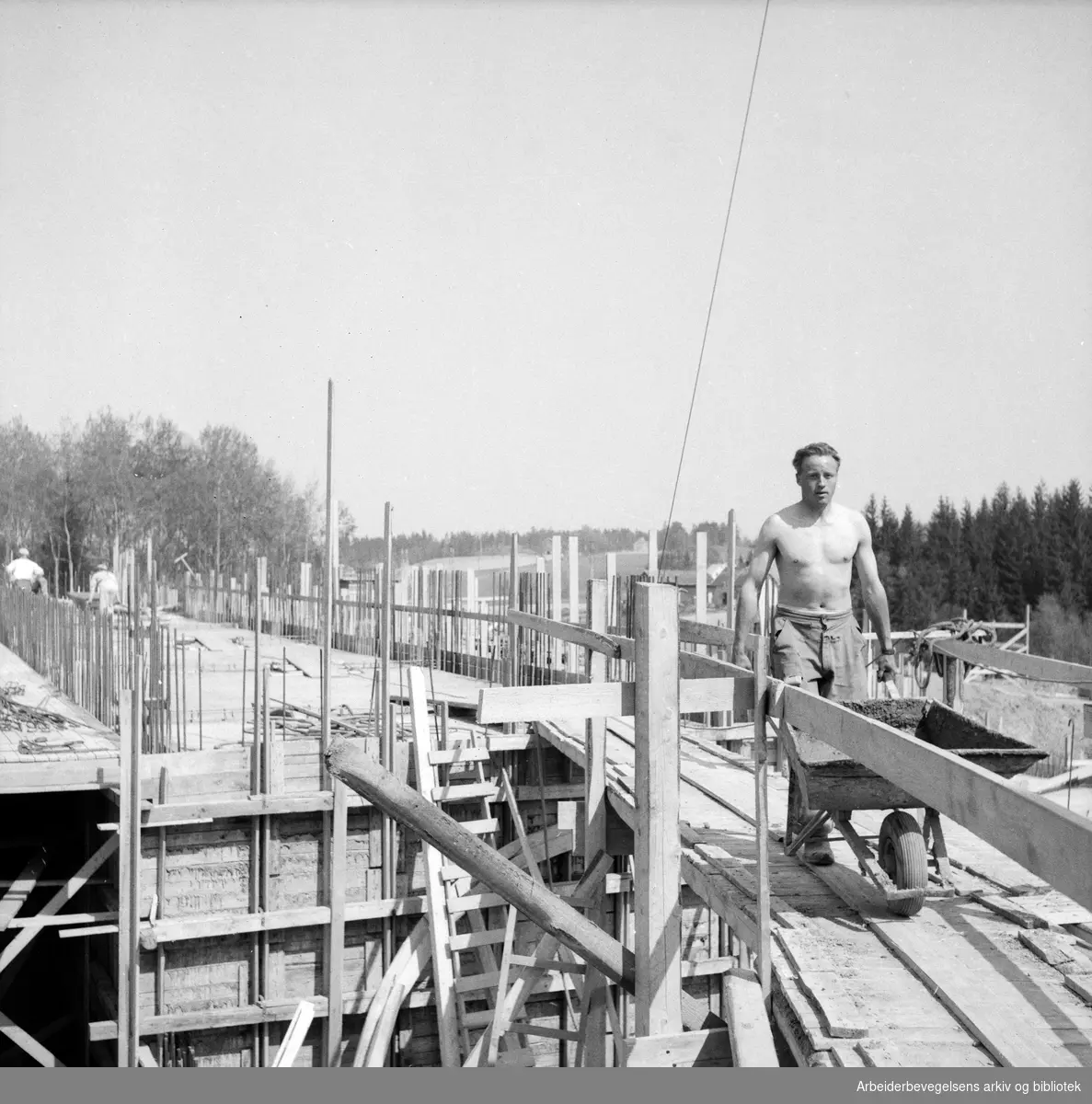 Mann med trillebår. Bygningsarbeider. Antatt Oslo. 1955 - 1960.