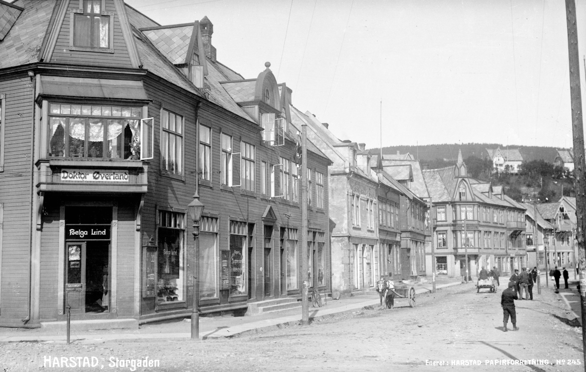 Postkort med bilde av Strandgata, fotografert fra Rikard Kaarbøs plass i retning mot Grand. Helga Lindgården, bygget 1901, til venstre.
