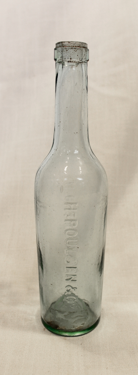 Halvflaske i glass fra H. Poulsen & Co, Kristiania. Romedal Brænderi hadde interessekontrakt med firmaet fra 1912 og tok senere over driften. 

Fra samlingen etter Ole Gjestvang. 